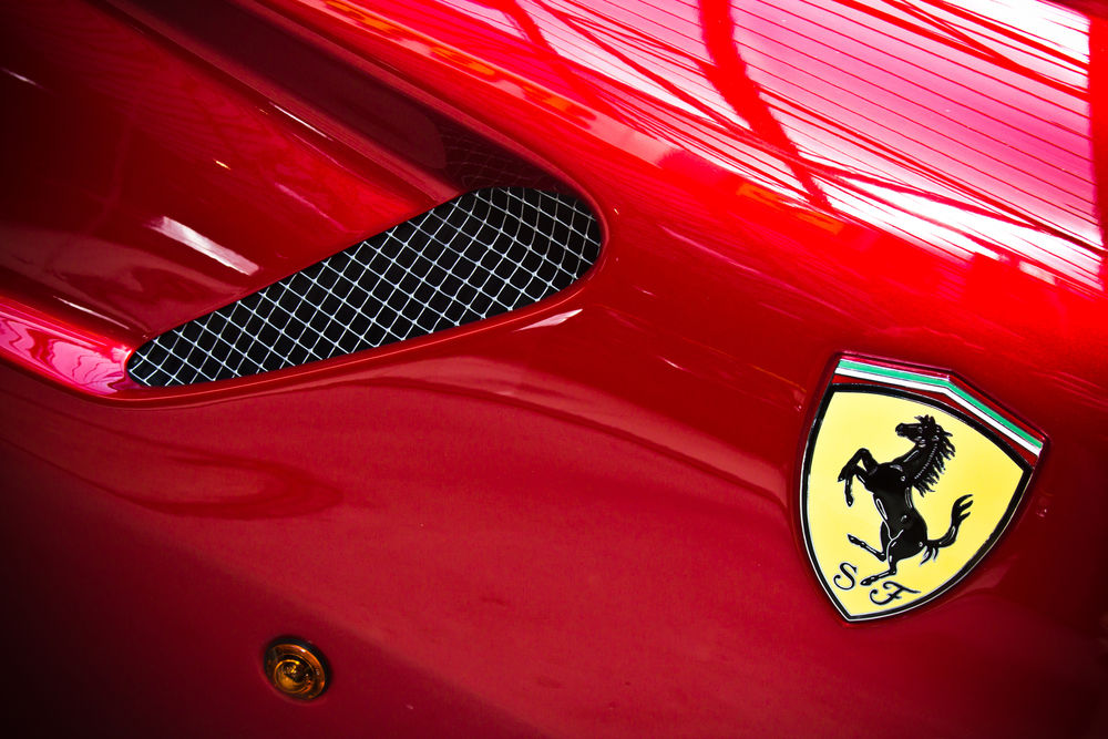 Обои для рабочего стола Шильдик Ferrari на крыле авто