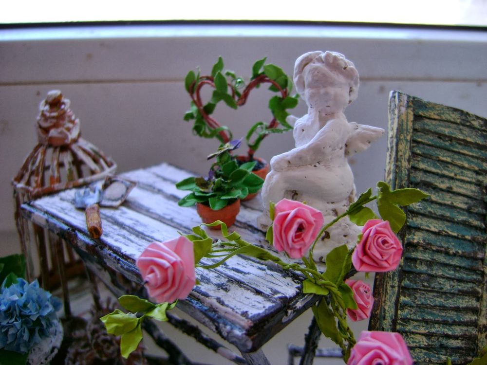 Обои для рабочего стола Ангелок на столе возле роз