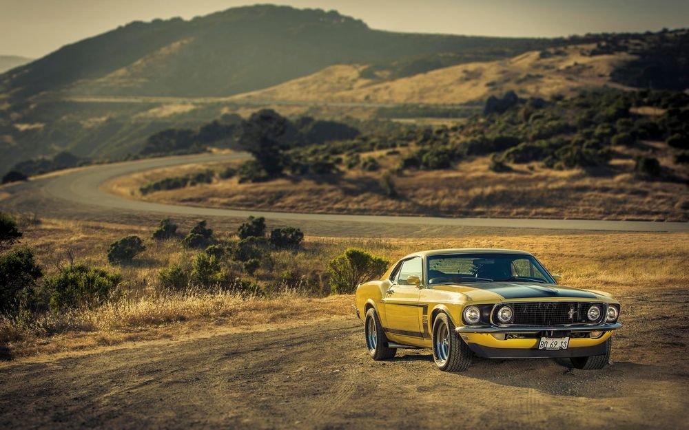 Обои для рабочего стола Ford Mustang на фоне горной дороги и гор