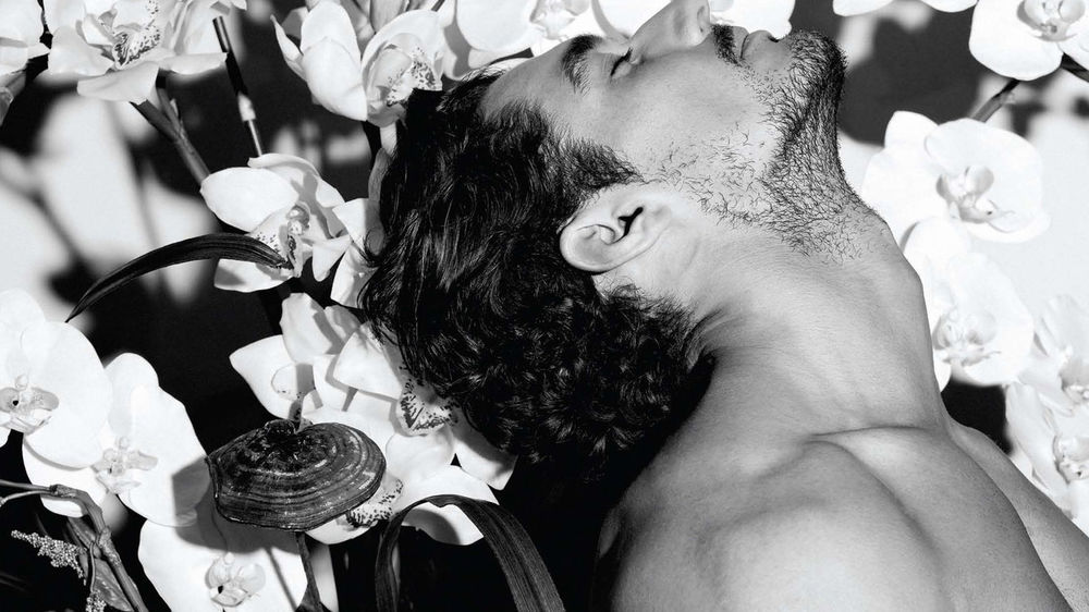 Обои для рабочего стола David Gandy / Дэвид Ганди запрокинувший голову на фоне белых цветов