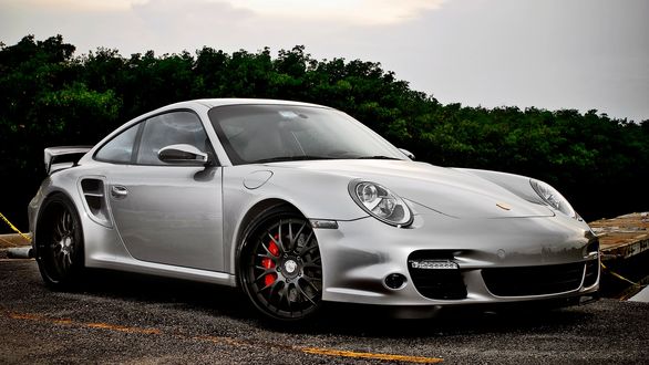 Обои на рабочий стол Серебряный porsche на дороге