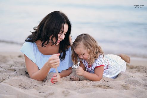 Обои на рабочий стол Девушка с девочкой лежат на морском песке Фотограф Александр Друкар