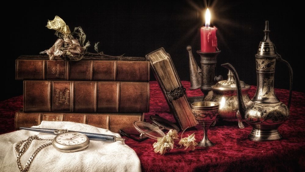 Обои для рабочего стола На ретро столе лежат книги часы на фоне стоит кувшинчик свеча,