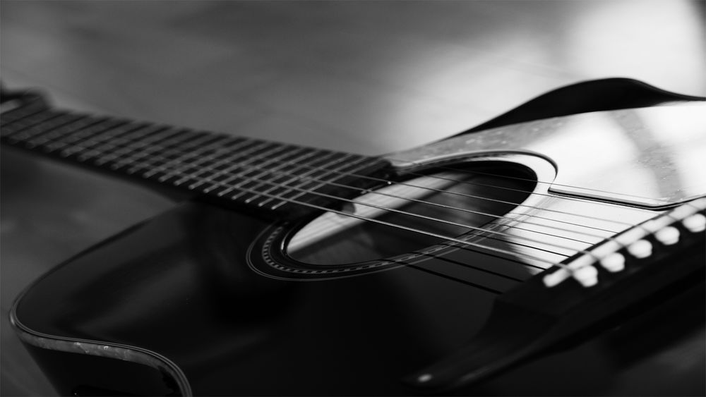 Черно-белый рисунок гитары со словом «гитара».