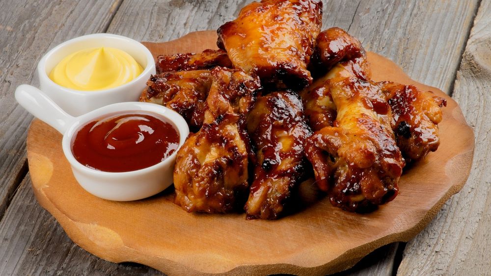 Обои для рабочего стола Доска с жареными куриными ножками и соусом