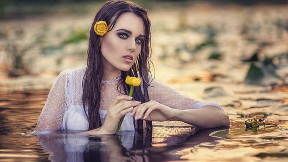 Обои на рабочий стол Девушка в воде с цветком в руке