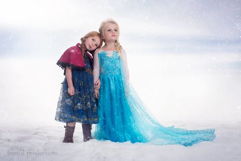Обои на рабочий стол Две девочки в костюмах из мультфильма Frozen / Холодное сердце, стоящие на белом фоне, автор Frosted Productions