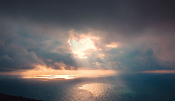 Обои на рабочий стол На поверхности морской воды отражаются солнечные лучи, проникающие сквозь облака, фотограф Дмитрий Рогожкин