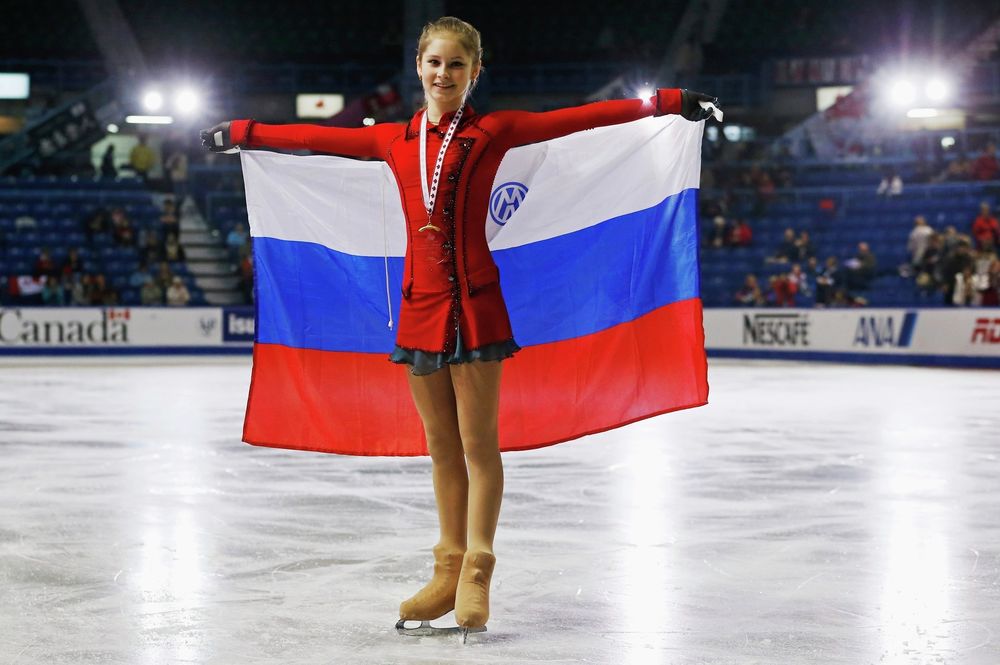 Обои для рабочего стола Фигуристка Юлия Липницкая позирует с российским флагом