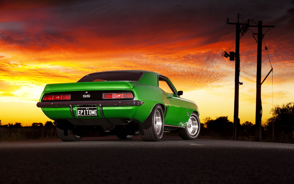 Обои для рабочего стола Зеленая Chevrolet Camaro SS 1969 года сзади на фоне заката