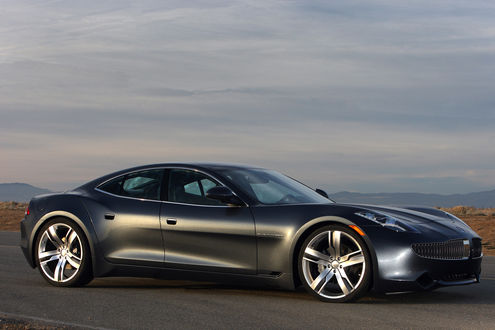 Обои на рабочий стол Автомобиль марки Fisker Karma, стоит на дороге на фоне гор и серого неба