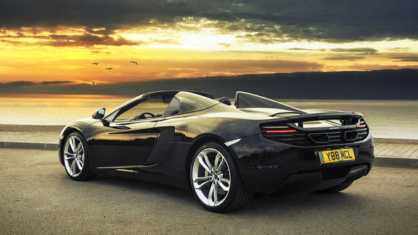 Обои на рабочий стол Автомобиль марки McLaren MP4-12C, стоит на дороге на фоне залива и неба озаряемого закатом