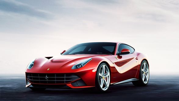 Обои на рабочий стол Красный автомобиль Ferrari стоит на дороге на фоне неба