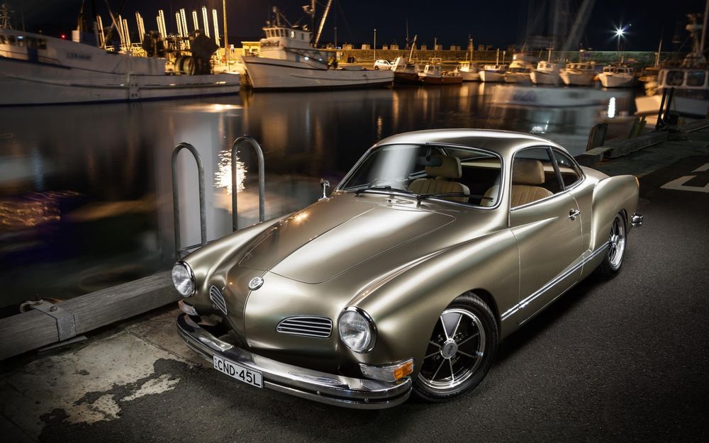 Обои для рабочего стола Автомобиль Volkswagen, karmann ghia, стоит на дороге около воды, на заднем плане яхты и катера
