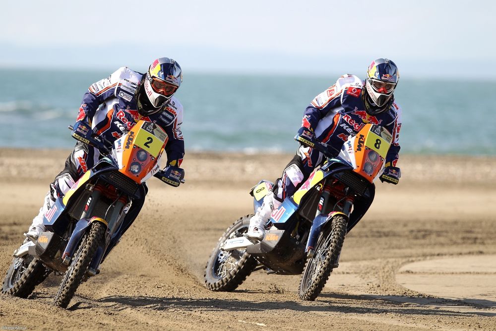 Обои для рабочего стола Двое мужчин мчат на мотоциклах по песчаному пляжу