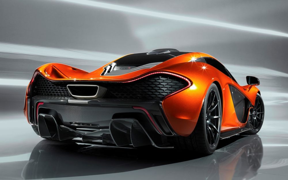 Обои для рабочего стола Оранжевый McLaren P1 на сером фоне, вид сзади