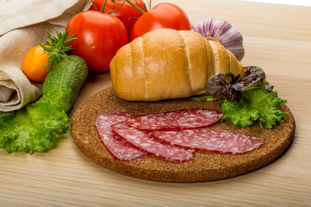 Обои для рабочего стола Доска с булочкой, овощами и колбаской