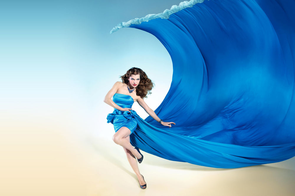 Обои для рабочего стола Милла Йовович американская актриса музыкант модель и модельер в платье синего цвета со шлейфом в виде морской волны