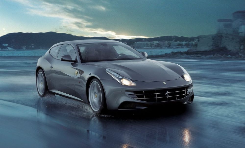 Обои для рабочего стола Автомобиль марки Ferrari FF, едет по мокрой дороге, на фоне гор, неба и домов