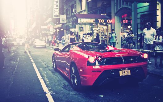 Обои на рабочий стол Красная Ferrari F430 стоит на дороге многолюдного города