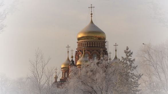 Обои на рабочий стол Заснеженный храм с золотыми куполами на фоне неба