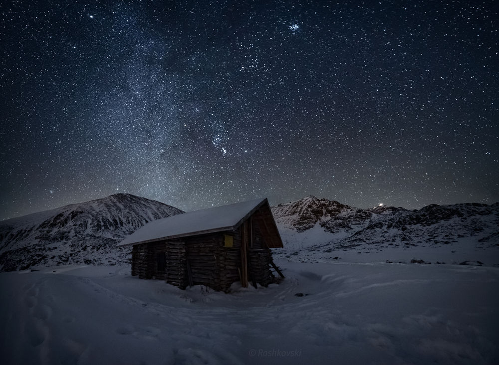 Обои для рабочего стола Заброшенный деревянный домик под ночным зимним небом, фотограф Емил Рашковски