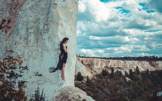 Обои на рабочий стол Девушка стоит на краю скалы, фотограф Martin Brest