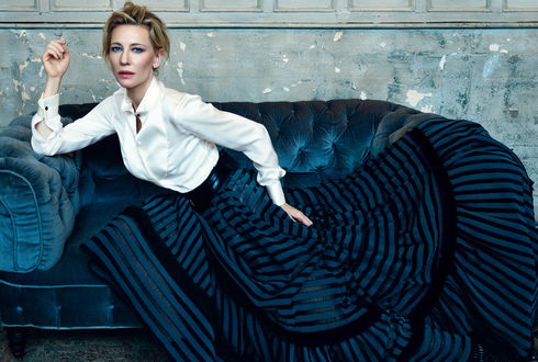Обои на рабочий стол Актриса Cate Blanchett в белой блузке и полосатой юбке сидит на диване