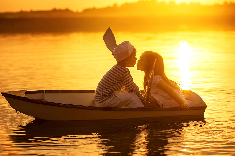 Обои для рабочего стола Юная пара влюбленных в лодке, на закате солнца
