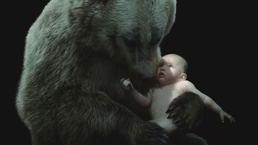 Обои для рабочего стола Огромная медведица с любовью прижимает к себе обнаженного человеческого детеныша