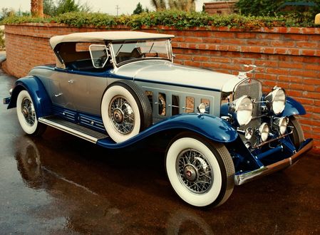 Обои на рабочий стол Автомобиль 1930 – 1931 Cadillac V16 452- 452- A Roadster: на дороге возле забора из красного кирпича