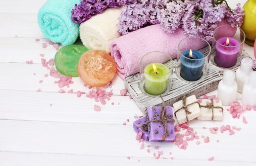 Обои на рабочий стол Spa набор, зажженные свечи, мыло, махровые полотенца и ветки сирени на белом фоне