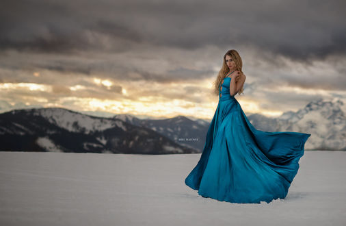 Обои на рабочий стол Девушка в длинном голубом платье стоит на снегу, ву Miki Macovei