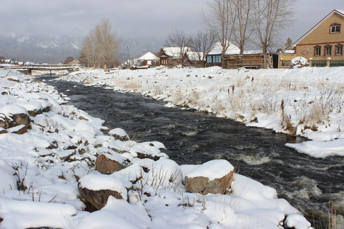 Обои на рабочий стол Речка Тюлюк на фоне гор и домов