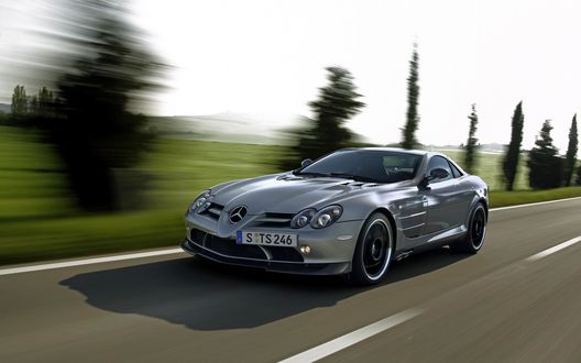 Обои на рабочий стол Автомобиль Mercedes Slr Mclaren на большой скорости едет по трассе, размытый фон