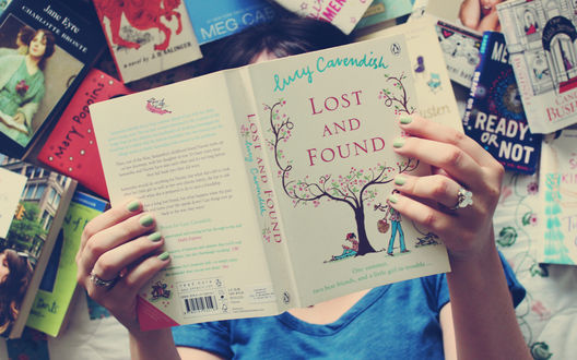 Обои на рабочий стол Девушка лежит среди книг, зачитавшись одной из них (Lury Carendish Lost and Found)