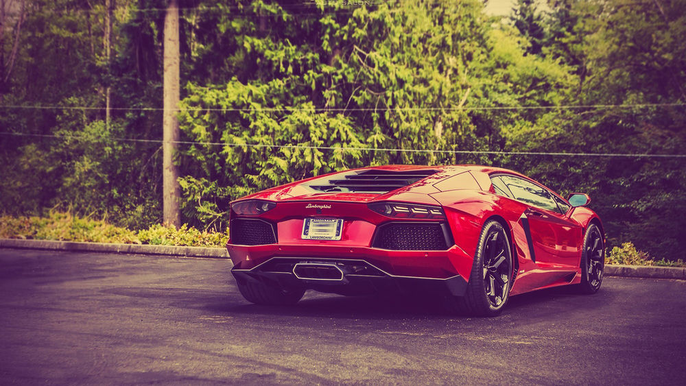 Обои для рабочего стола Красная Lamborghini на парковке около леса