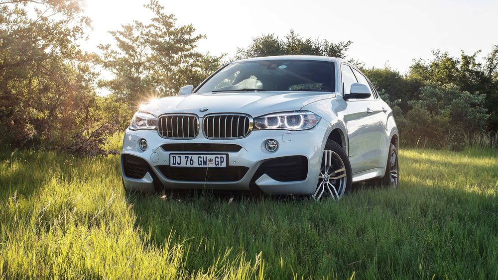 Обои для рабочего стола Белый BMW в поле за городом