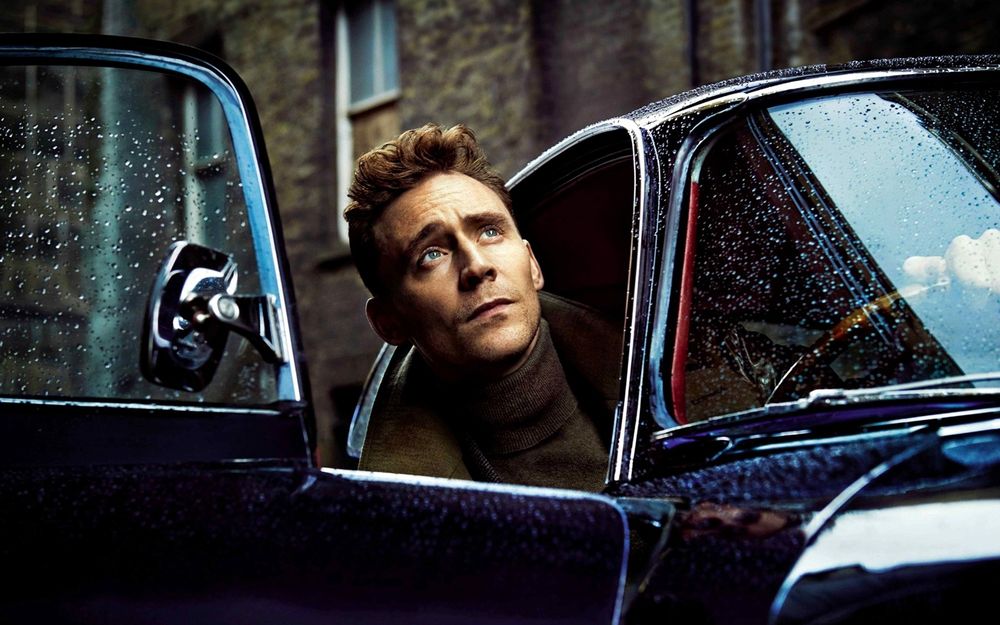 Обои для рабочего стола Актер Том Хиддлстон / Tom Hiddleston высунул голову из машины и смотрит вверх