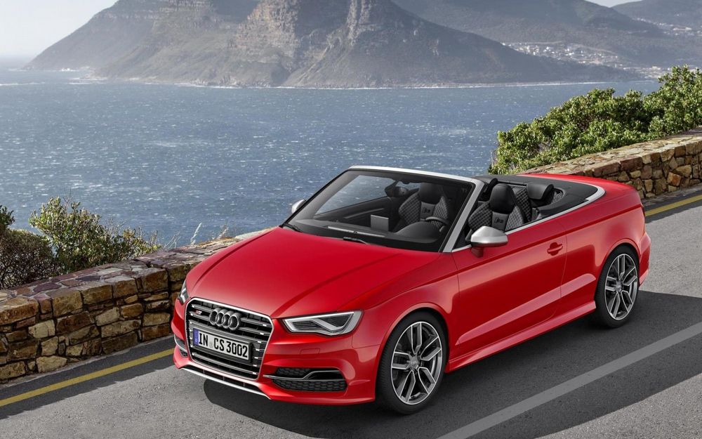 Обои для рабочего стола Audi S3 Cabriolet 2015 года, красного цвета стоит на дороге на фоне моря и горы