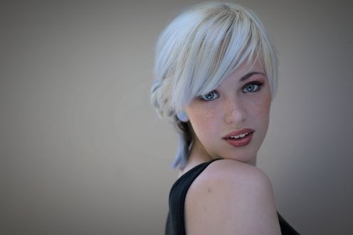 Обои на рабочий стол Красивая сероглазая блондинка с веснушками Devon Jade / Дэвон Джейд, вполоборота, улыбаясь с приоткрытым ртом смотрит в камеру