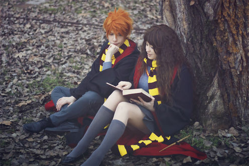 Обои на рабочий стол Косплей Рон Уизли / Ronald Weasley и Гермиона Грейнджер / Hermione Granger из фильма Гарри Поттер / Harry Potter сидят под деревом на осенней листве