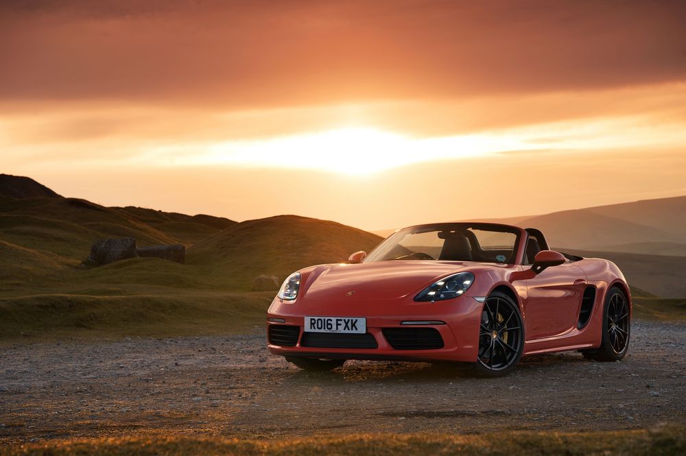 Обои для рабочего стола Кабриолет Porsche 718 Boxster, 2016 года, оранжевый металлик, на фоне равнины и прекрасного заката солнца