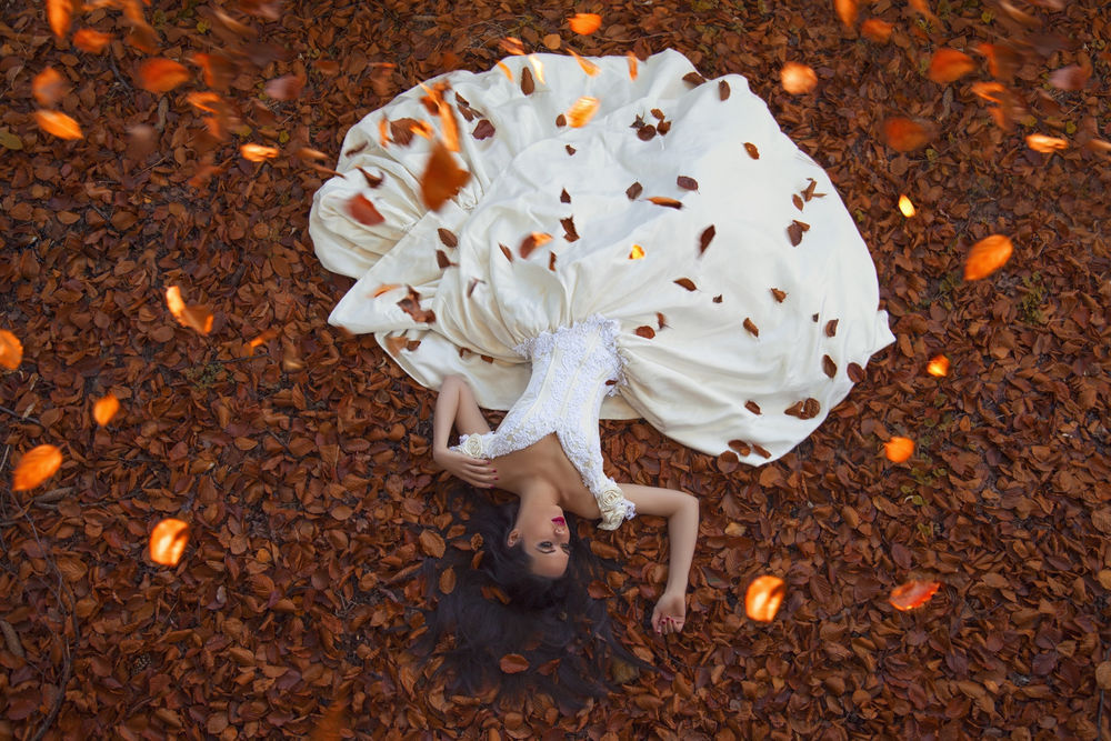Обои для рабочего стола Брюнетка в пышном кремовом платье с белыми кружевами лежит на опавшей осенней листве, Maja Topcagic Photography
