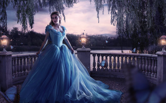 Обои на рабочий стол Актриса Лили Джеймс / Lily James в роли Золушки / Cinderella из одноименного фильма сказки, в пышном голубом платье стоит на балконе в окружении бабочек