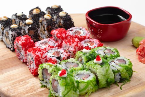 Обои на рабочий стол Японская кухня: роллы с рыбой и икрой, маринованный имбирь и миска с соусом