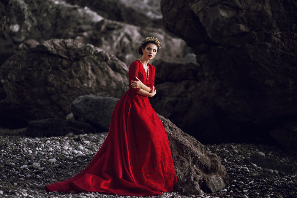 Обои для рабочего стола Девушка в красном длинном платье стоит у скал, фотограф Sofi Buzakova
