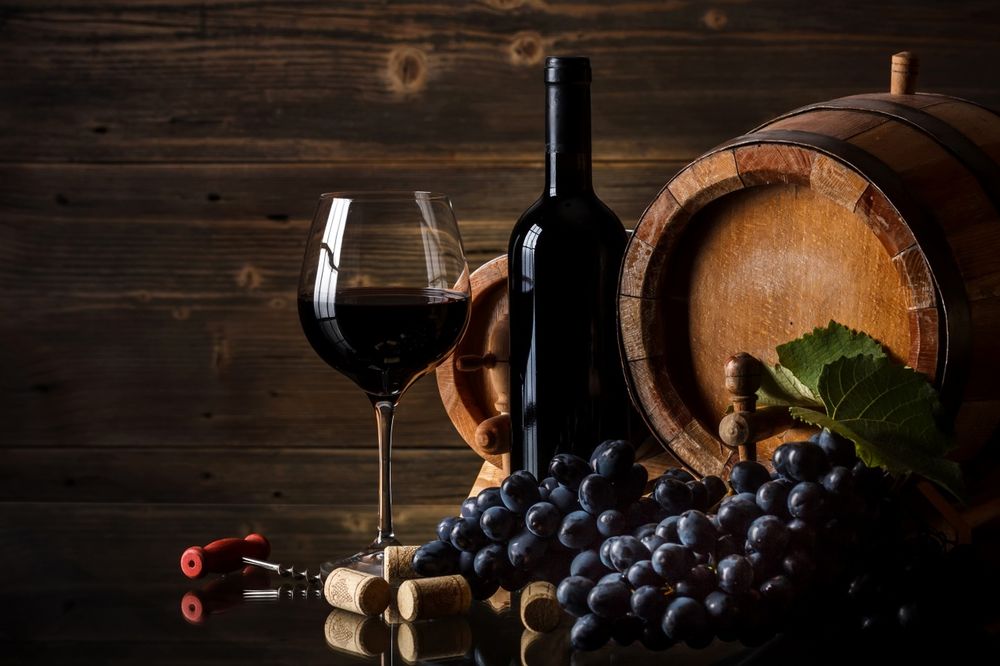 Обои на рабочий стол Бутылка красного вина, бокал с вином, черный виноград,  штопор для открывания вина и два небольших бочонка с вином на фоне  деревянной стены, обои для рабочего стола, скачать обои,