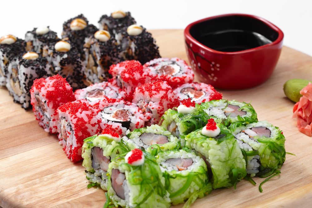 Обои для рабочего стола Японская кухня: роллы с рыбой и икрой, маринованный имбирь и миска с соусом