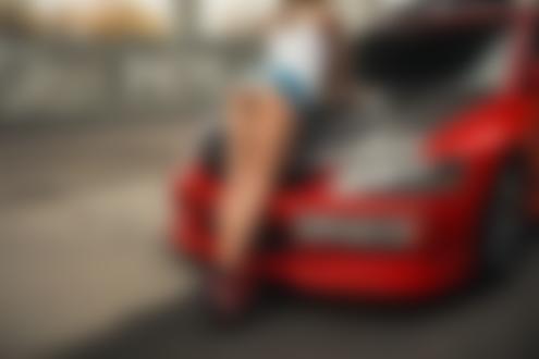 Обои на рабочий стол Девушка в шортах и майке стоит у авто